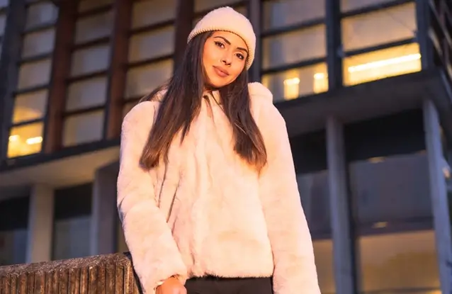 Smiling young brunette model wearing Fleece Hoodie in winter in the city