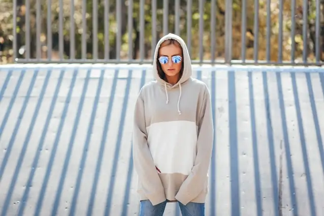 Stylish woman in a hoodie with sunglasses