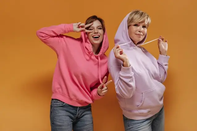 2 women pulling hoodie drawstrings