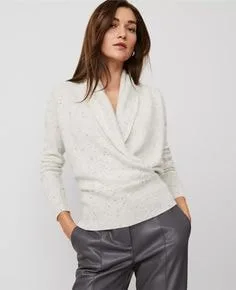 Model wearing a cream wrap-front sweater with a speckled texture, highlighting elegant sweater styles for chic fashion.