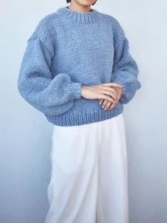 Model wearing a light blue oversized sweater with balloon sleeves and a crew neck, showcasing relaxed sweater styles for casual fashion.