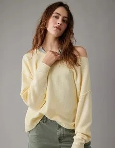 Model wearing a light yellow off-shoulder slouchy sweater with long sleeves, paired with green pants, showcasing relaxed sweater styles for casual fashion.