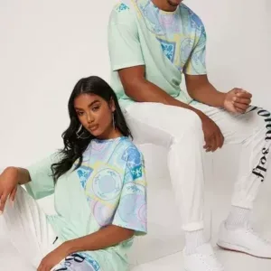 Male and female models wearing coordinated pastel graphic T-shirts and white pants, made by a clothing manufacturer.